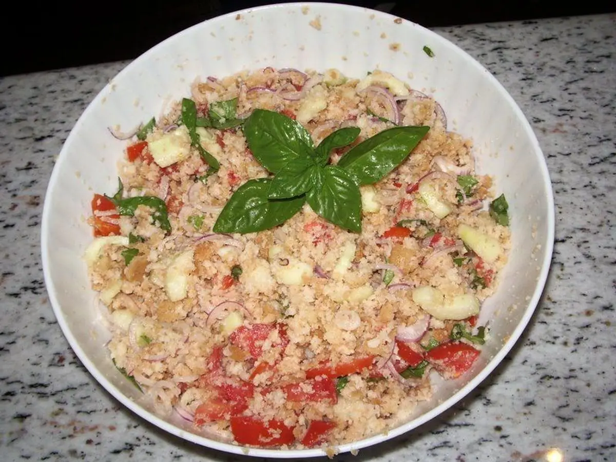 Cuenco de panzanella con pan, tomate, pepino y albahaca fresca