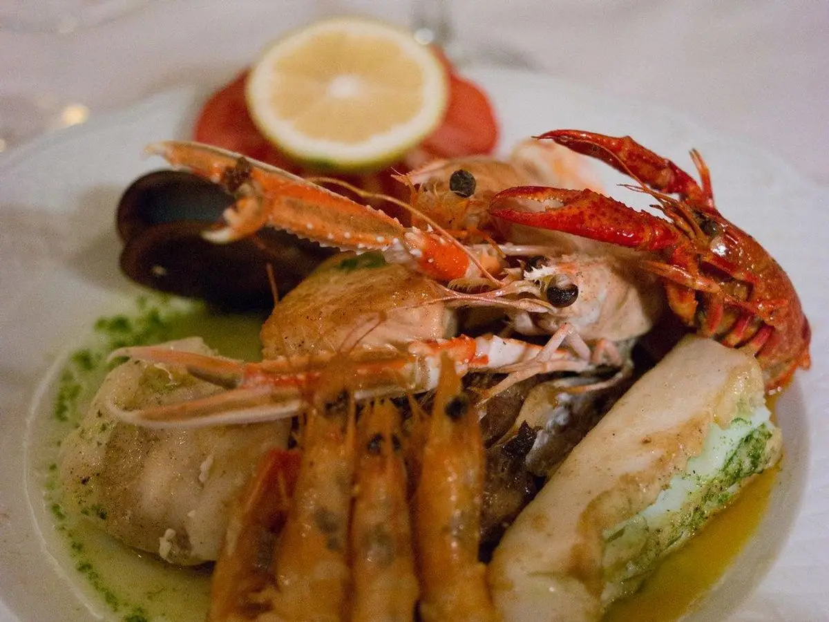 Parrillada de marisco a la plancha con gambas, cigalas y pescado en un plato con limón