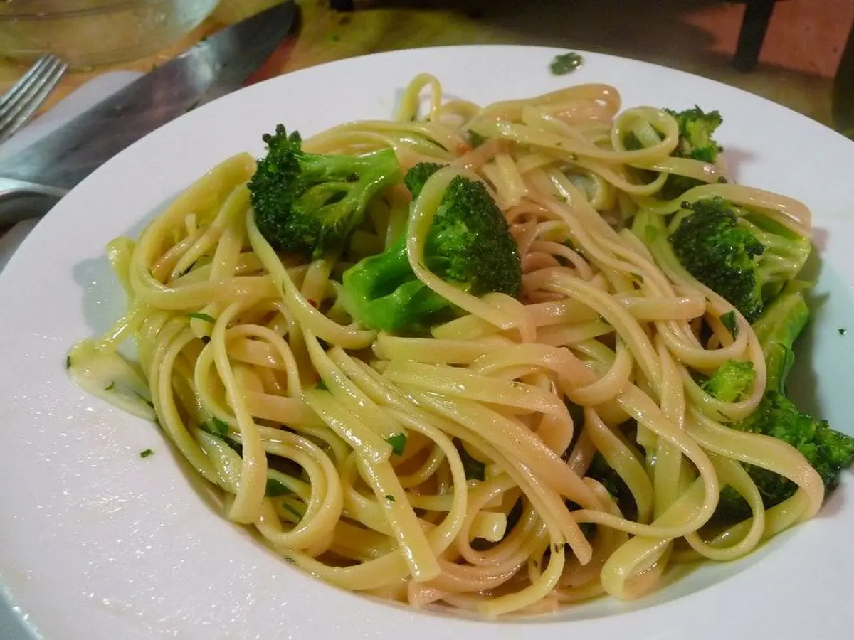 Plato blanco de tallarines con brócoli y ajo