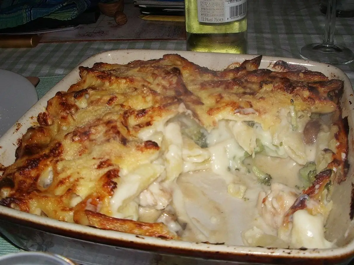 Pastel gratinado de pescado y patata en una fuente blanca sobre la mesa