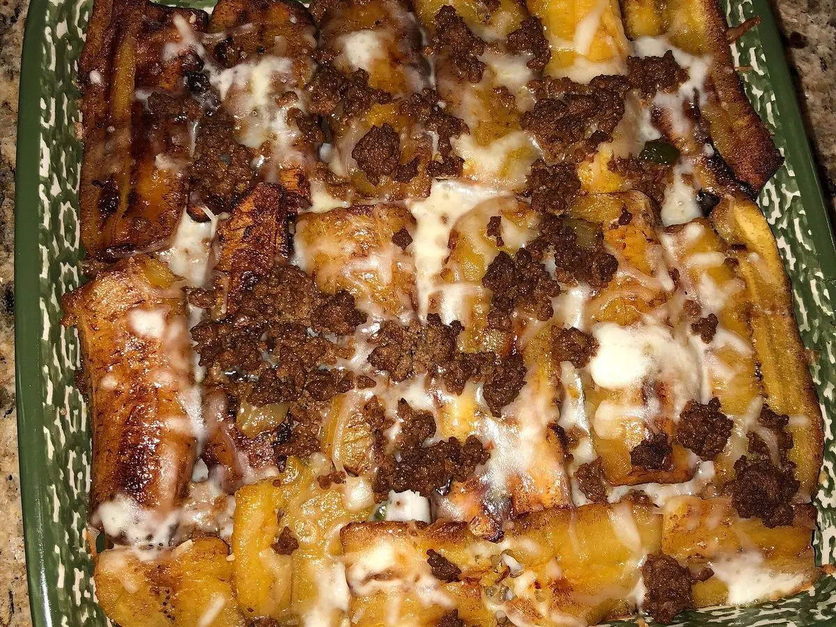 Fuente de pastelón con capas de plátano maduro y carne picada dorada por encima