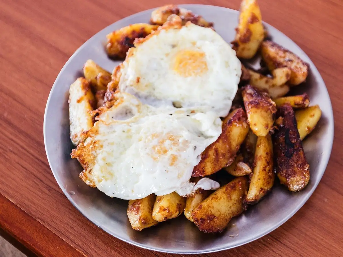 Plato con patatas troceadas doradas y dos huevos fritos encima