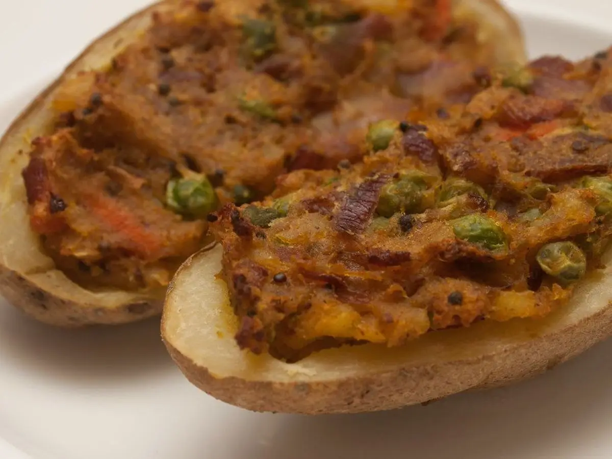 Mitades de patata asada rellenas de picadillo con guisantes