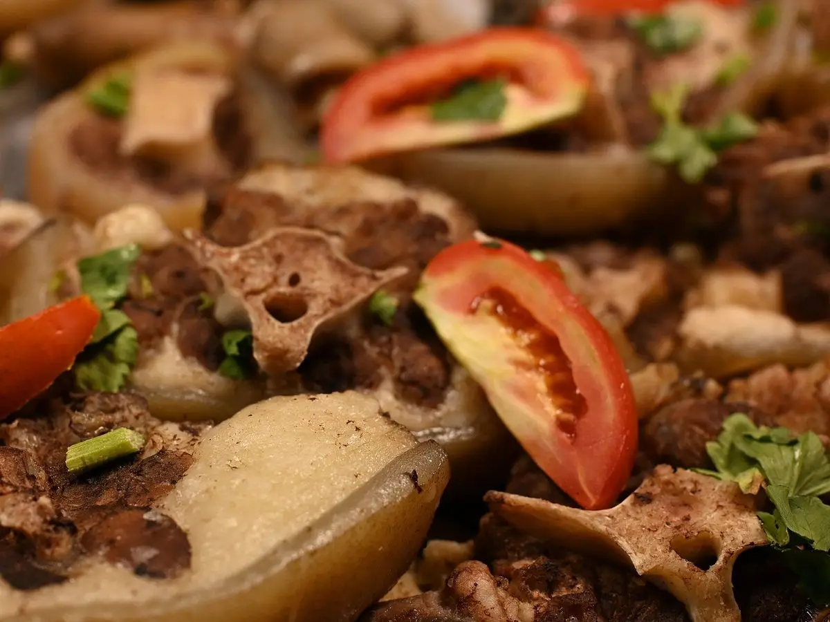 Patatas asadas rellenas de carne picada con rodajas de tomate