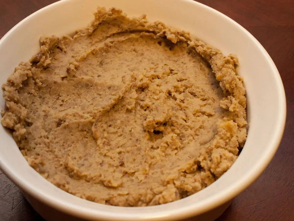 Cuenco blanco lleno de paté vegetal de textura rugosa de color marrón claro