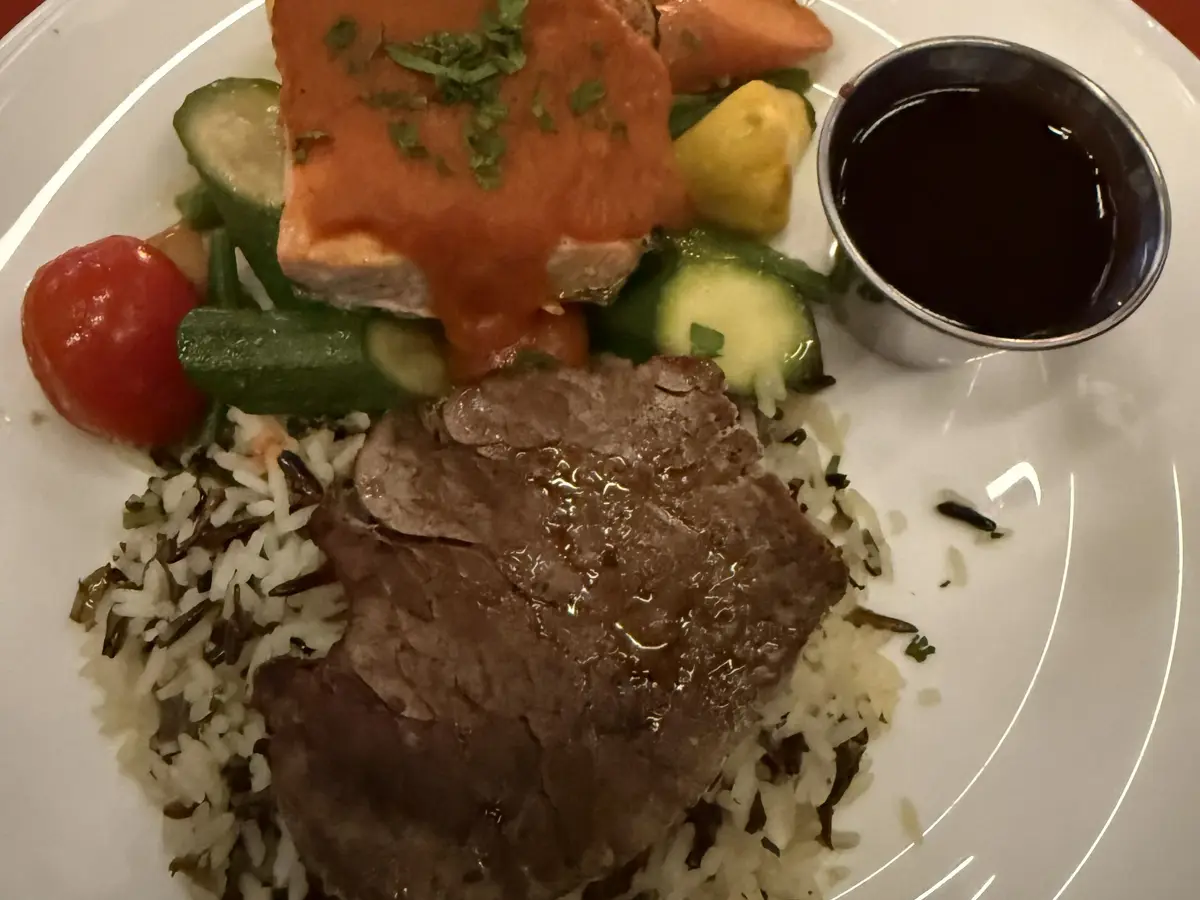 Filete de carne sobre arroz salvaje con verduras salteadas y salsa aparte