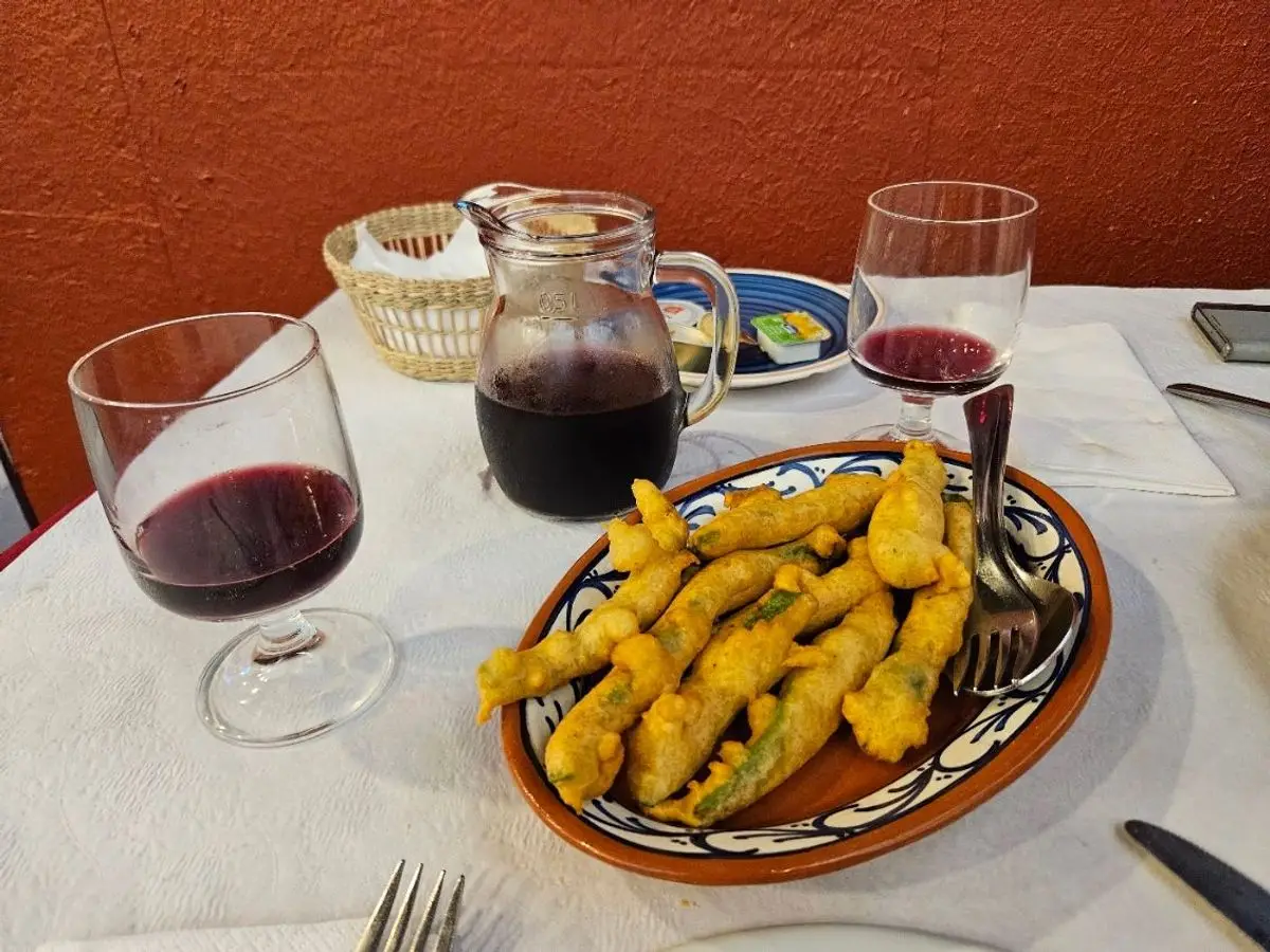 Fuente de cerámica con peixinhos da horta, judías verdes rebozadas y fritas, junto a copas de vino tinto