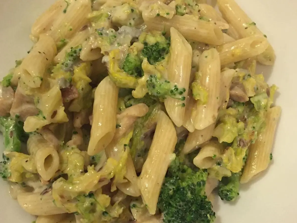 Penne con salsa de queso azul, brócoli, col verde y pollo en un plato