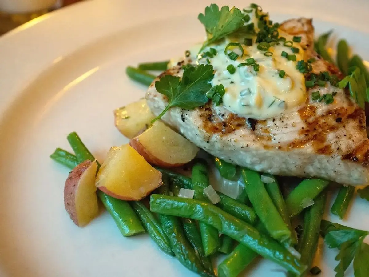 Filete de pez espada a la plancha con salsa de hierbas sobre judías verdes y patatas pequeñas