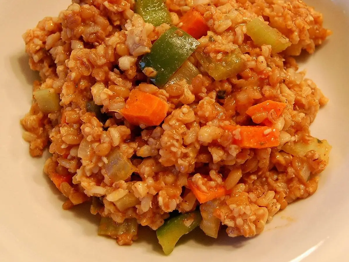 Plato de bulgur guisado con pimiento, zanahoria y tomate