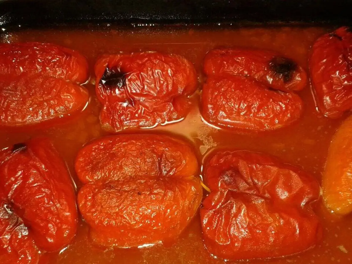 Bandeja de pimientos rojos rellenos y asados al horno en su salsa de tomate