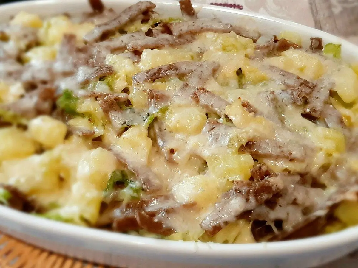 Fuente blanca de pizzoccheri gratinados con patata, verduras y queso fundido