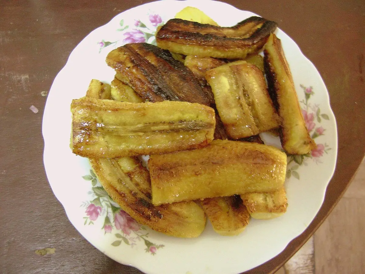Plato con rodajas de plátano macho maduro dorado y frito sobre una vajilla floreada
