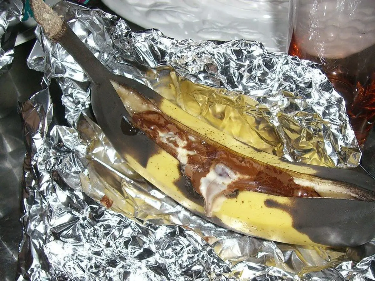 Plátano abierto en su papillote de papel de aluminio, asado y listo para comer