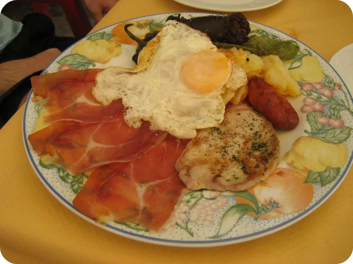 Plato alpujarreño con huevo frito, jamón, chorizo, morcilla, lomo y patatas a lo pobre
