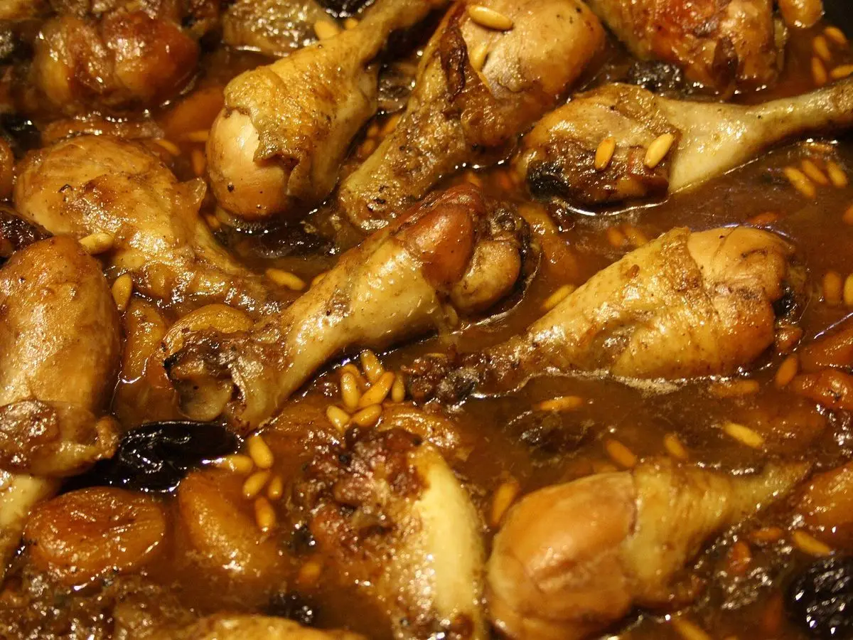 Muslos de pollo dorados y brillantes en salsa oscura