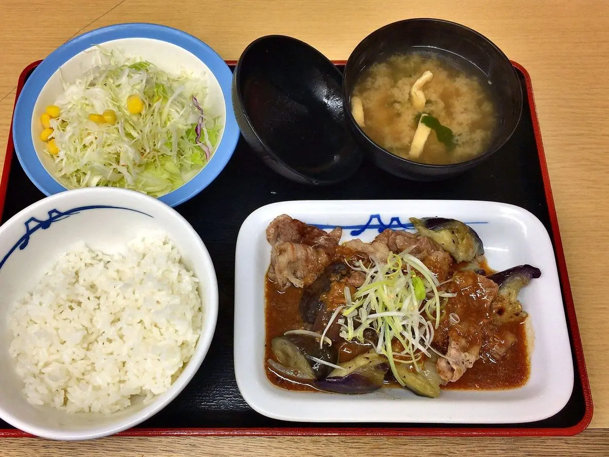 Menú japonés en bandeja con arroz blanco, carne con berenjena al miso, ensalada y sopa de miso