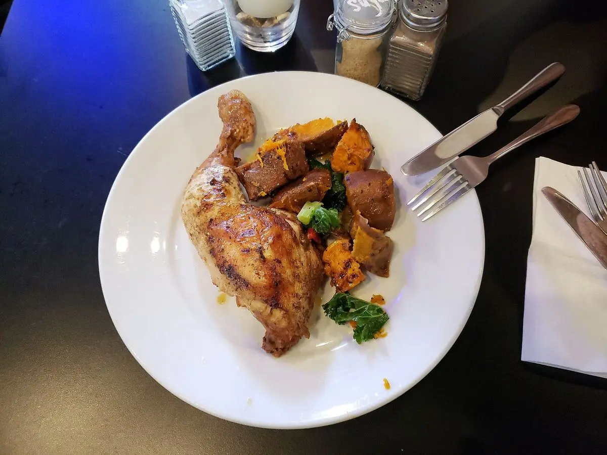 Plato con muslo de pollo asado, batata y verdura salteada