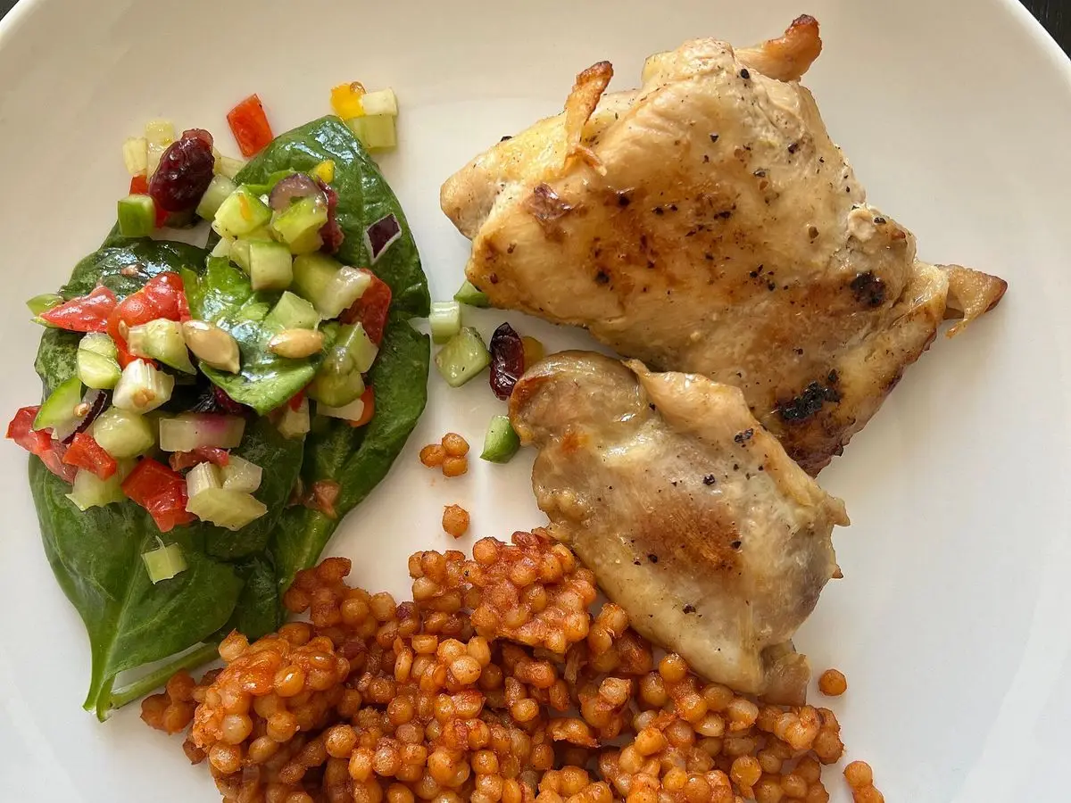 Muslos de pollo a la plancha con ensalada de pepino, tomate y pimiento picados