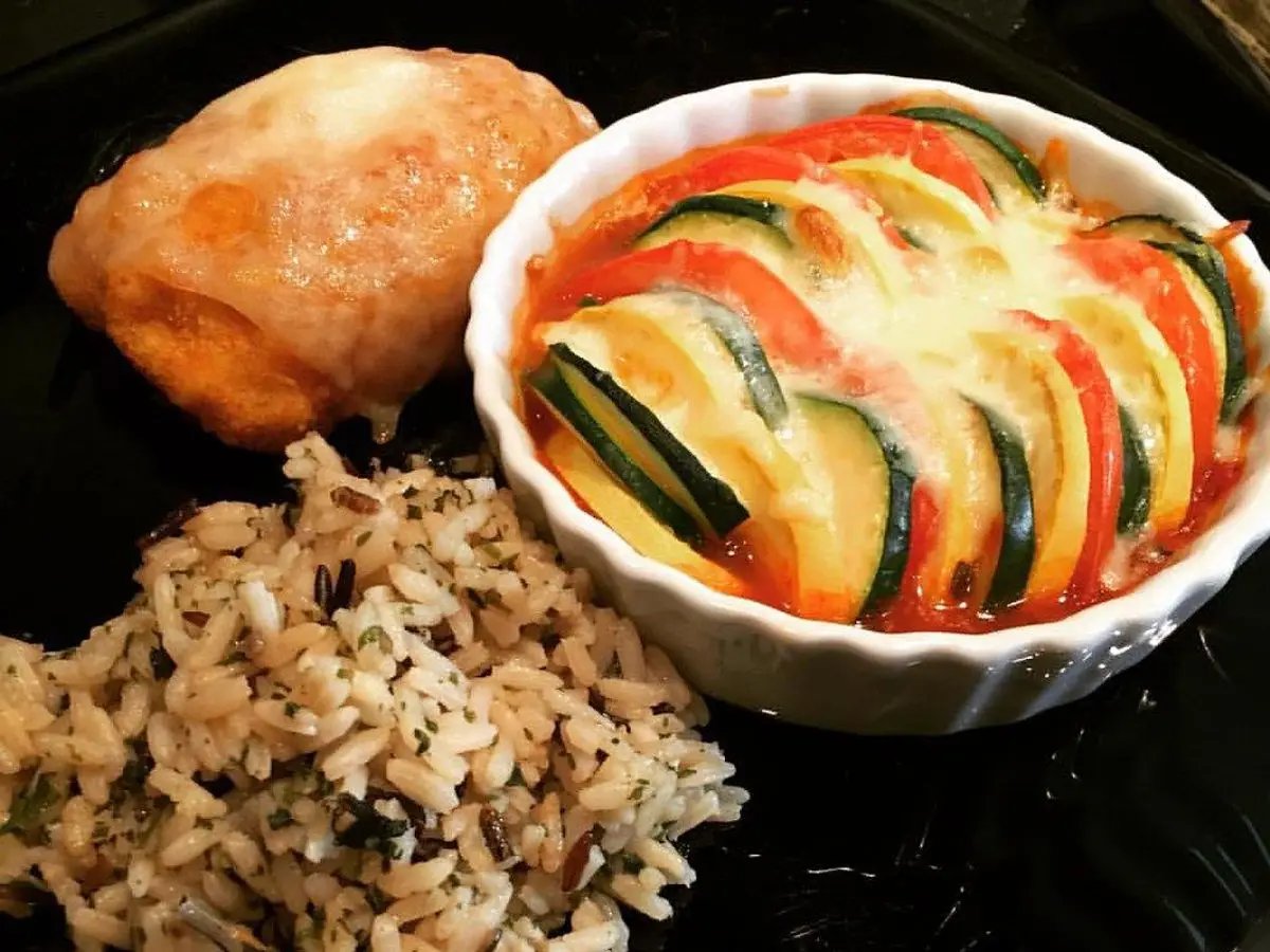 Pollo empanado con arroz integral y un molde de verduras en rodajas asadas