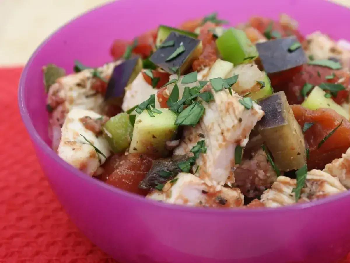 Cuenco de pollo troceado con verduras en cubos de calabacín, berenjena y tomate