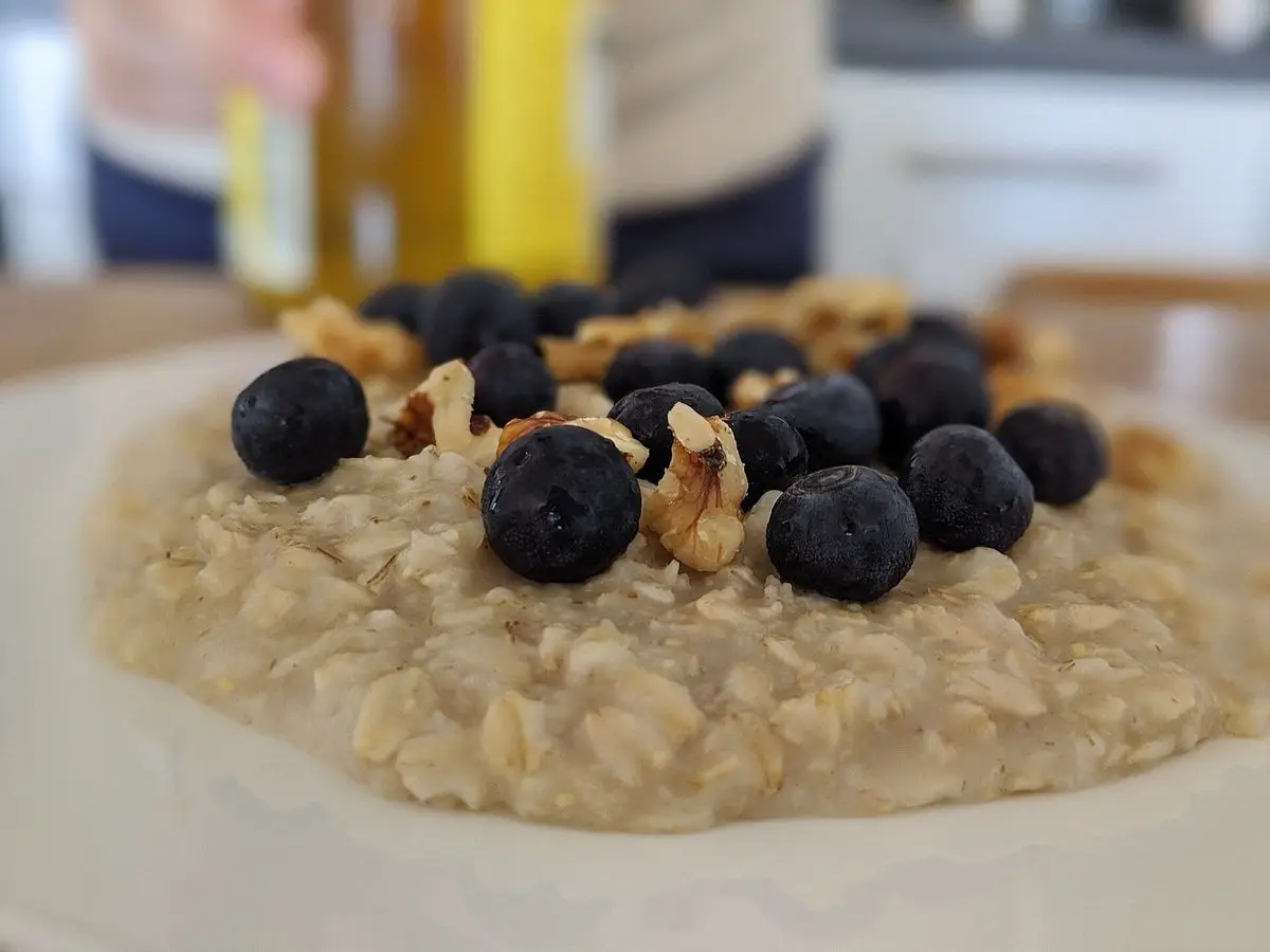 Plato de porridge de avena con arándanos y nueces troceadas