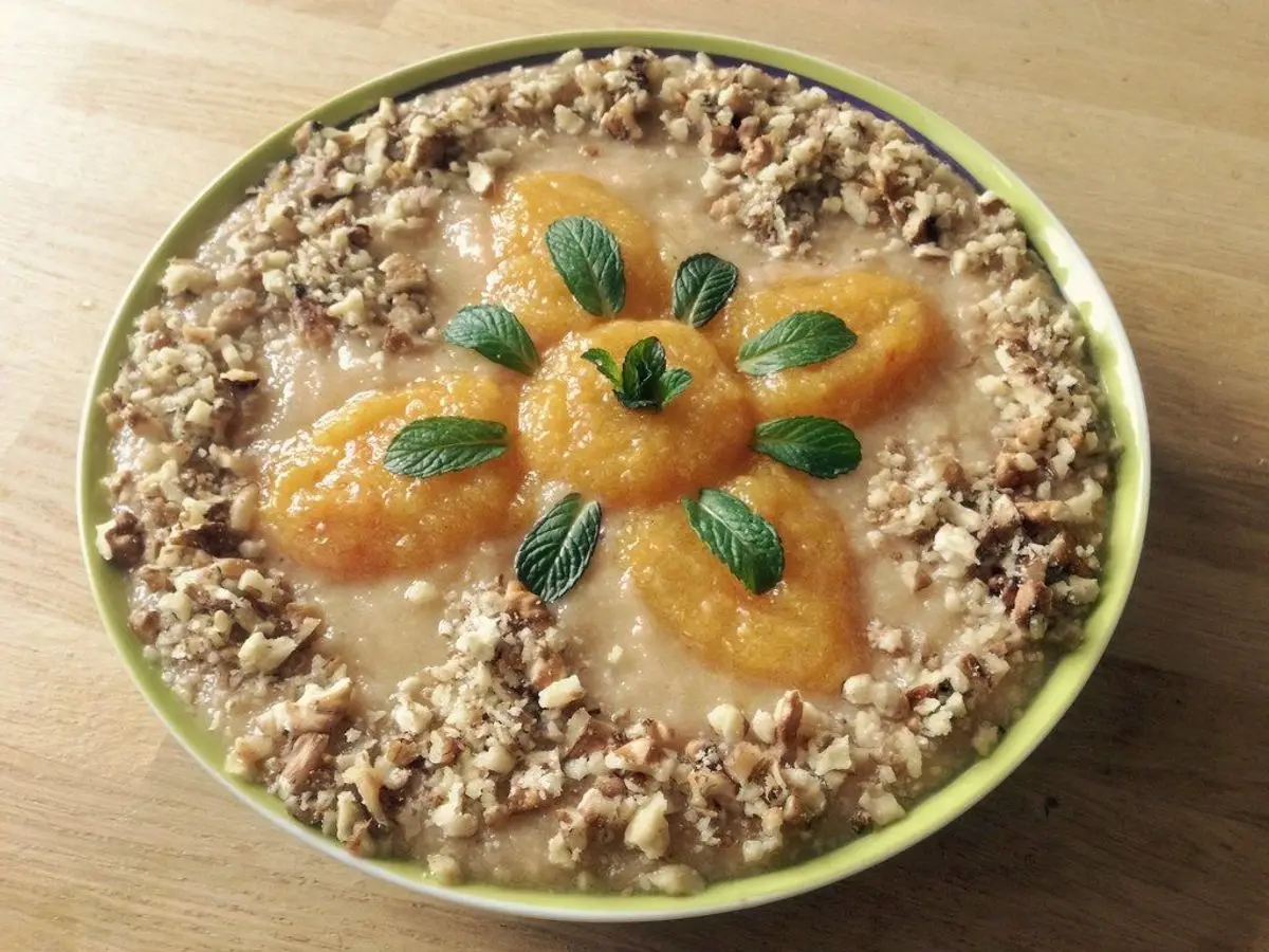 Cuenco redondo de avena y cereal crujiente decorado con gajos de naranja y hojas de menta