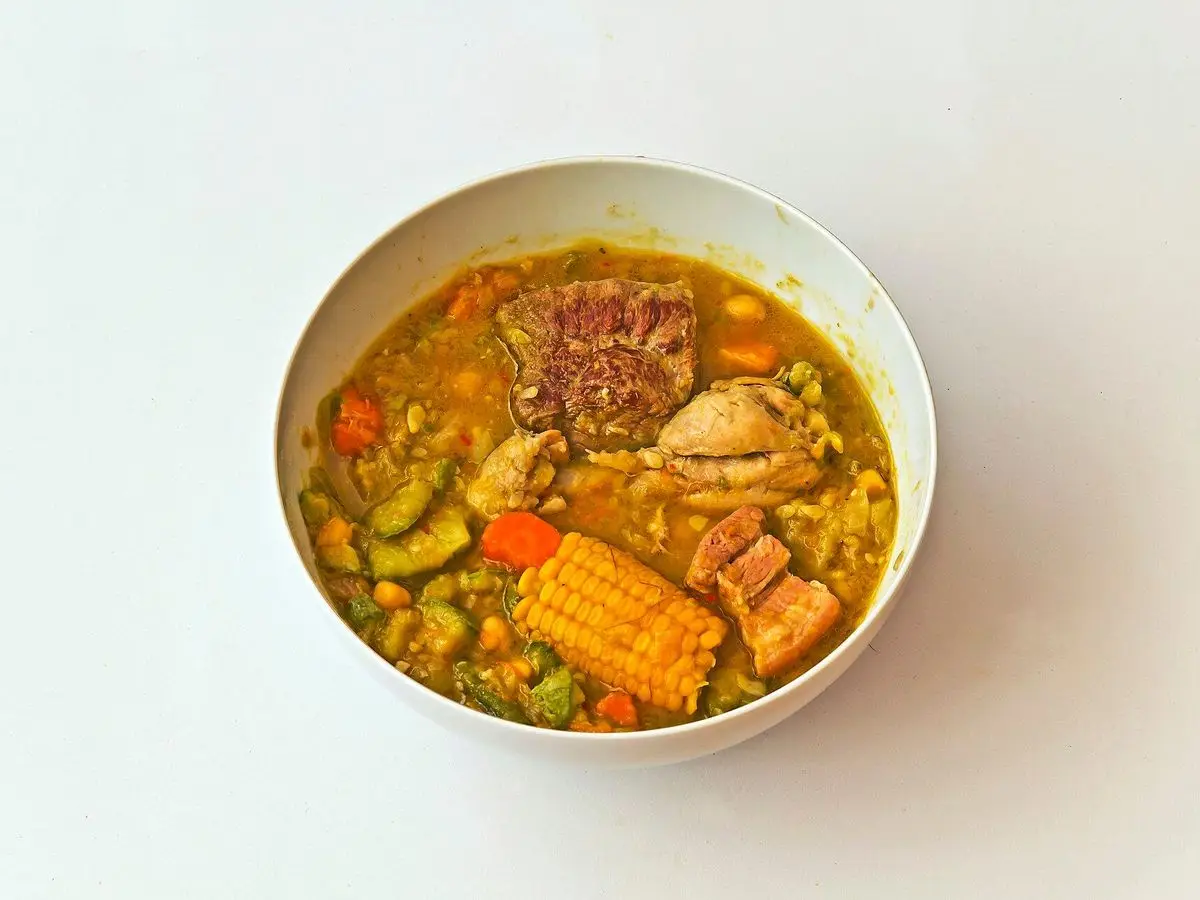 Cuenco de potaje canario con calabacín, mazorca de millo, zanahoria y trozos de carne en su caldo