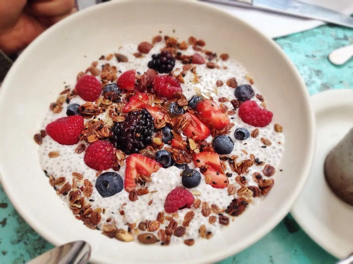 Cuenco de pudin de chía con frutos rojos, arándanos y granola por encima
