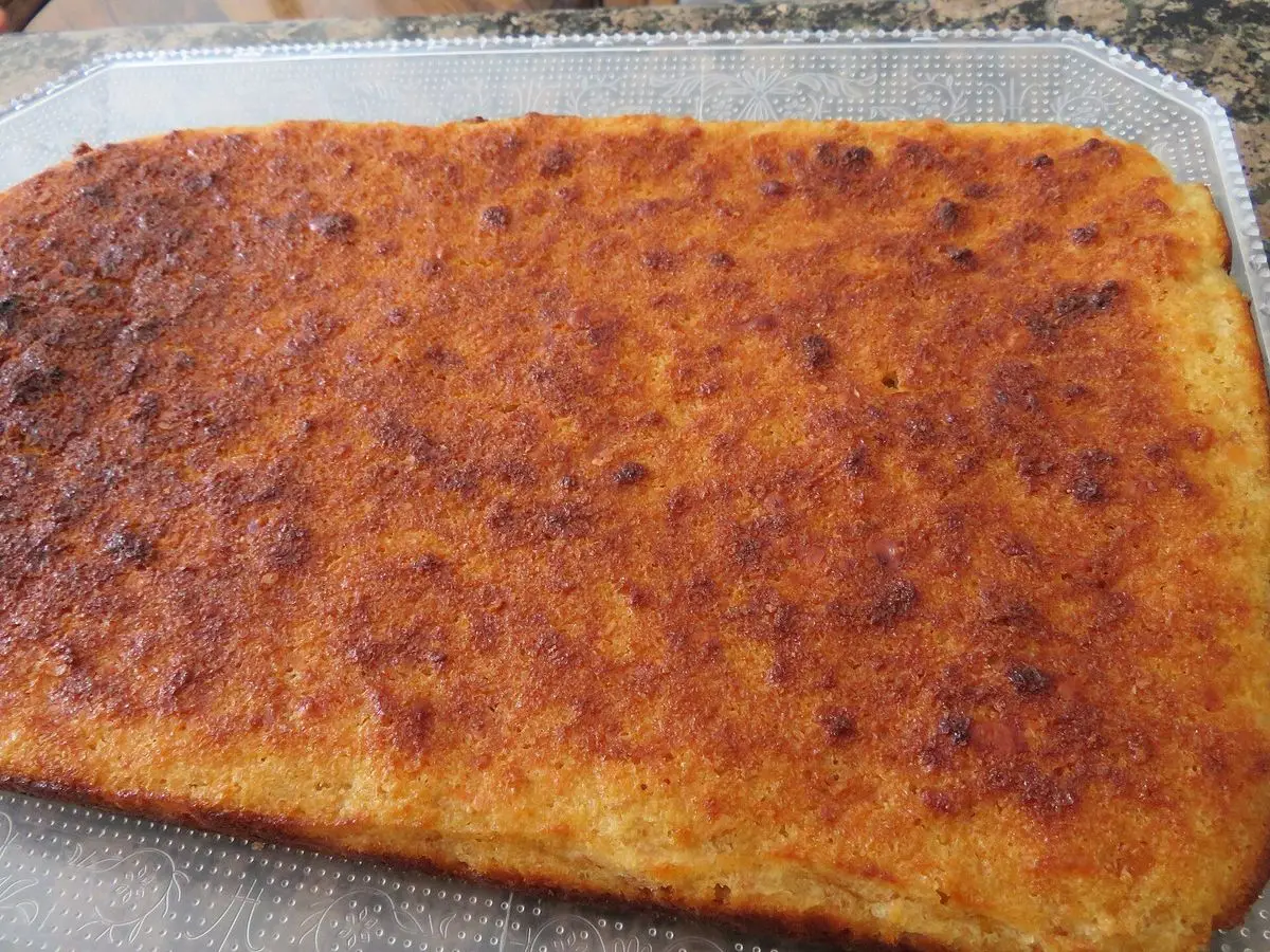 Quesada pasiega rectangular dorada y caramelizada por encima en una bandeja
