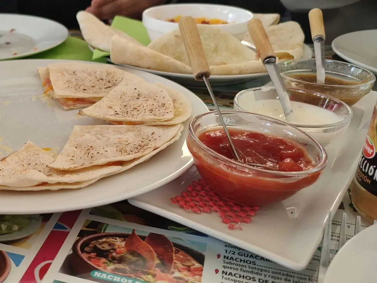 Tortillas rellenas cortadas en triángulos dispuestas en círculo sobre un plato blanco