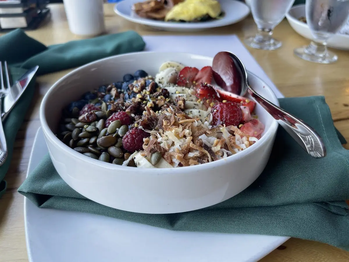 Bol cremoso con fresas, arándanos, frambuesas, plátano, nueces y semillas