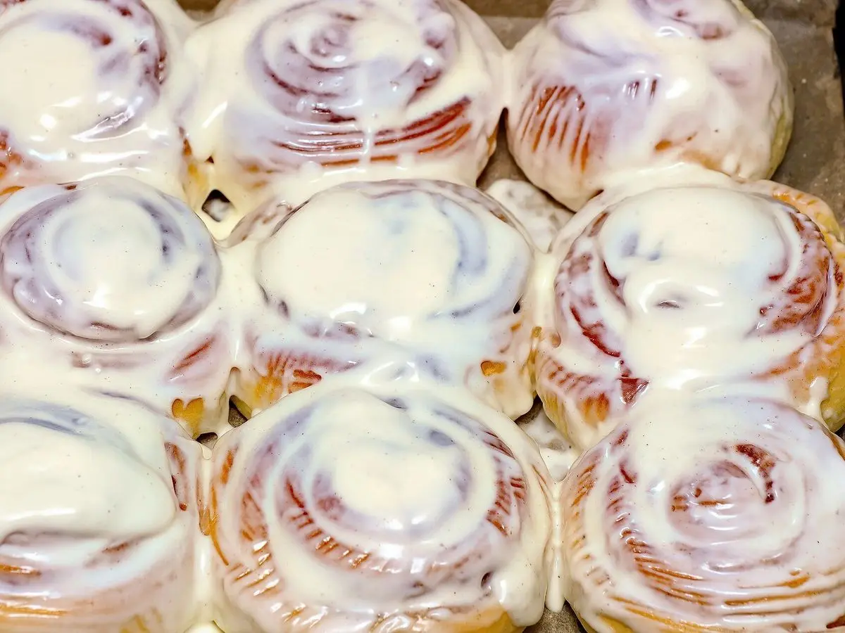 Bandeja de rollos de canela horneados cubiertos de glaseado blanco