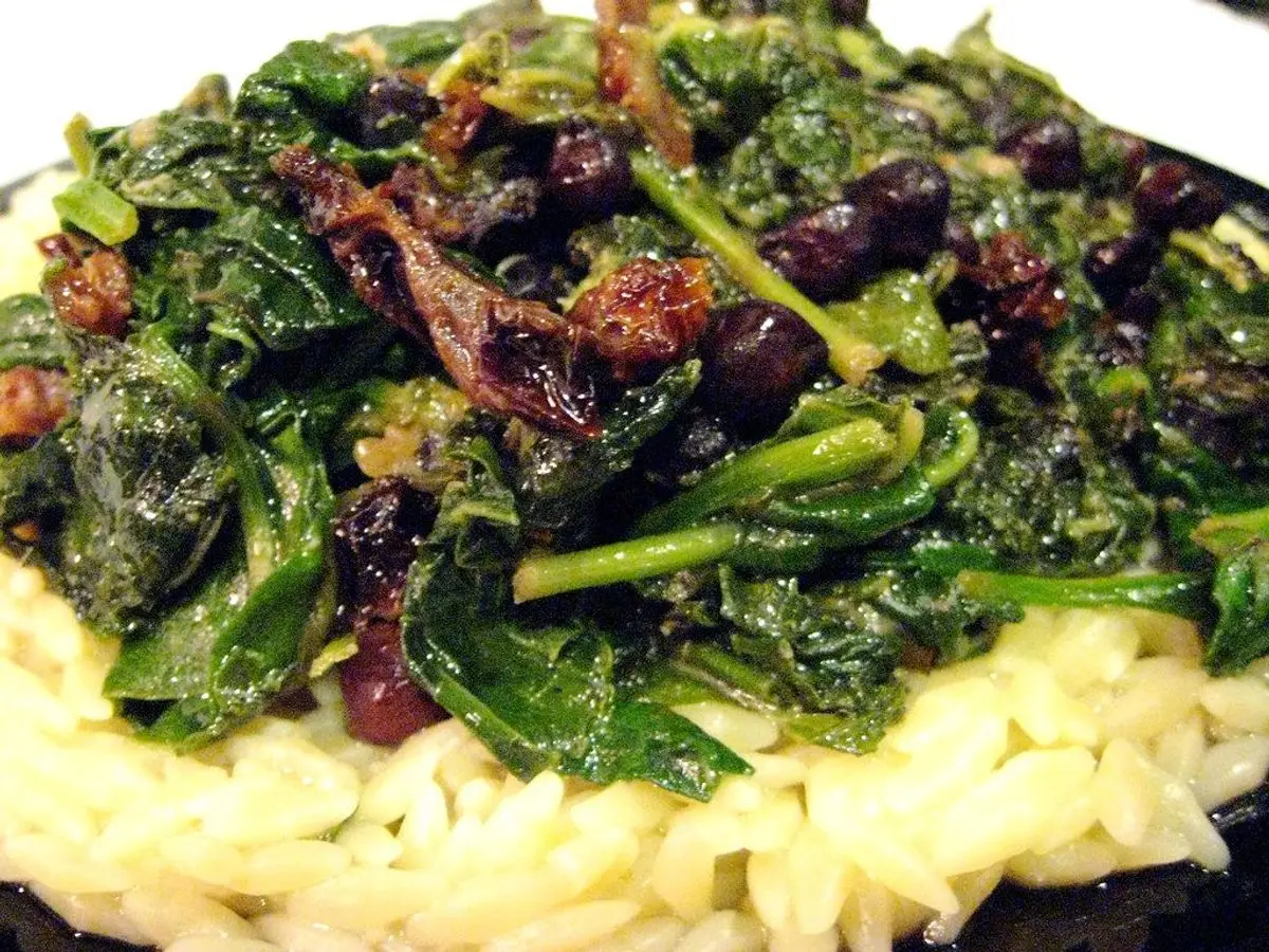 Plato con garbanzos, hojas verdes salteadas y tomates secos