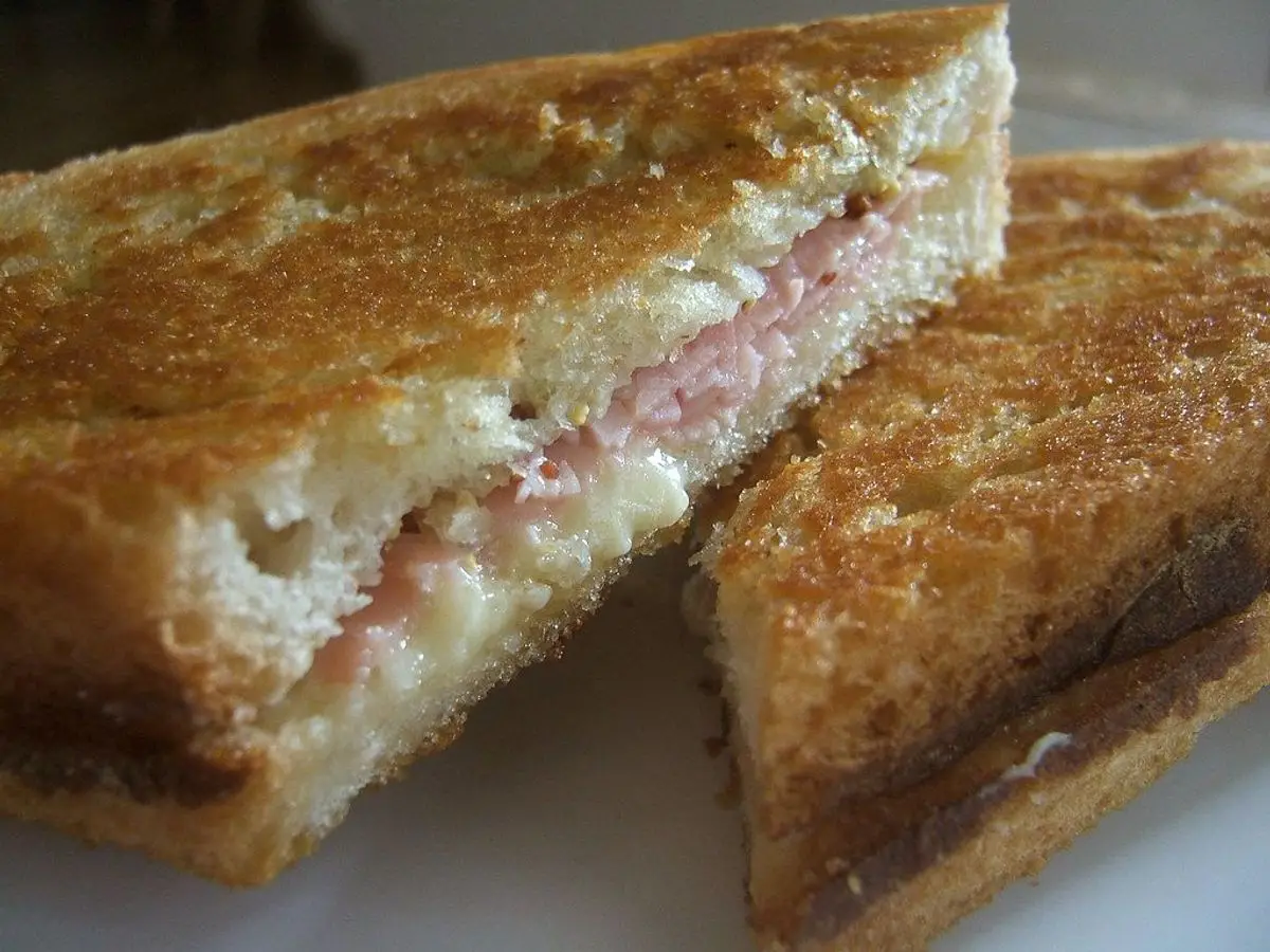 Sándwich mixto tostado de jamón y queso cortado en triángulos
