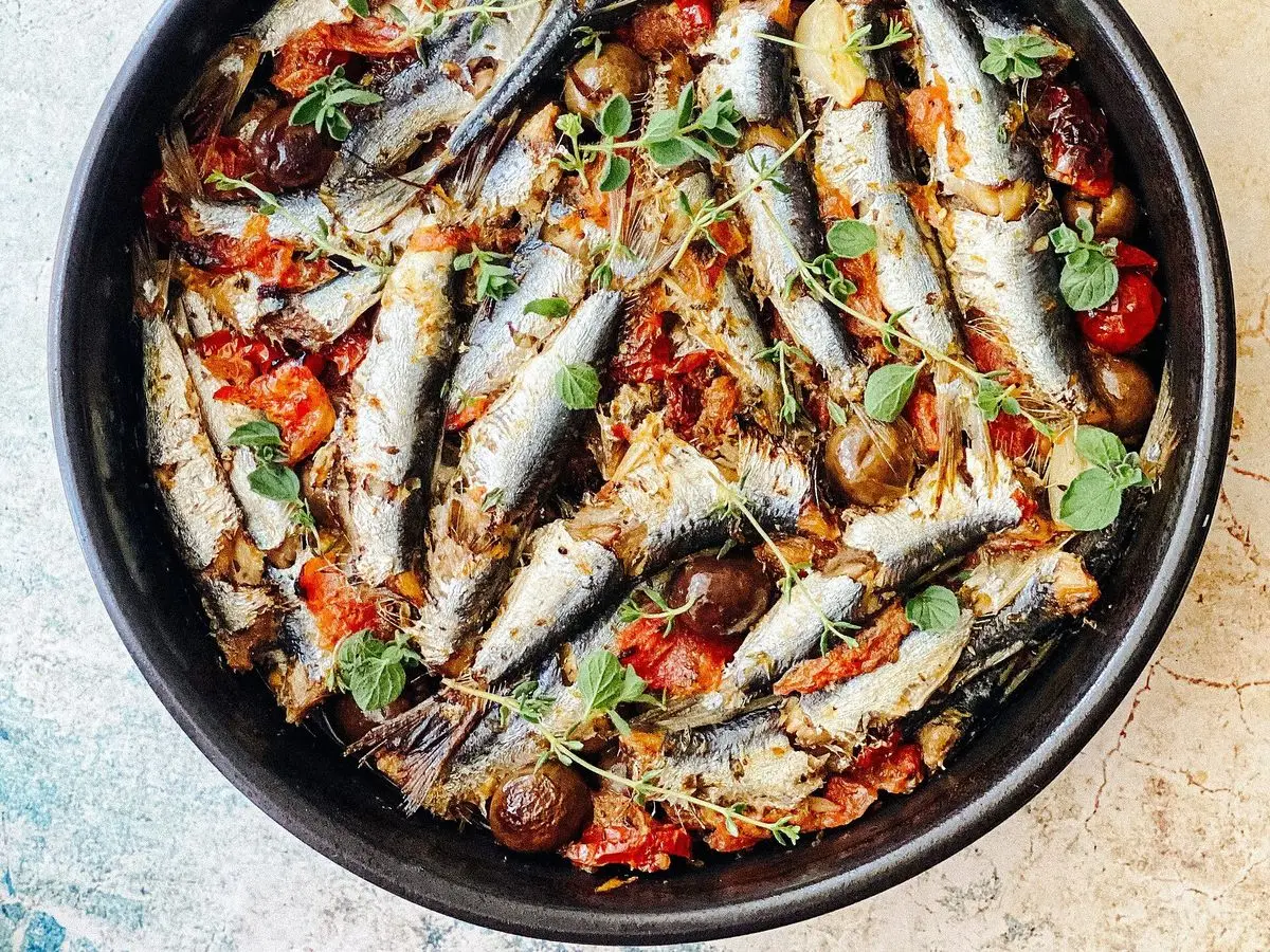 Fuente negra con sardinas al horno con tomate, aceitunas y tomillo fresco