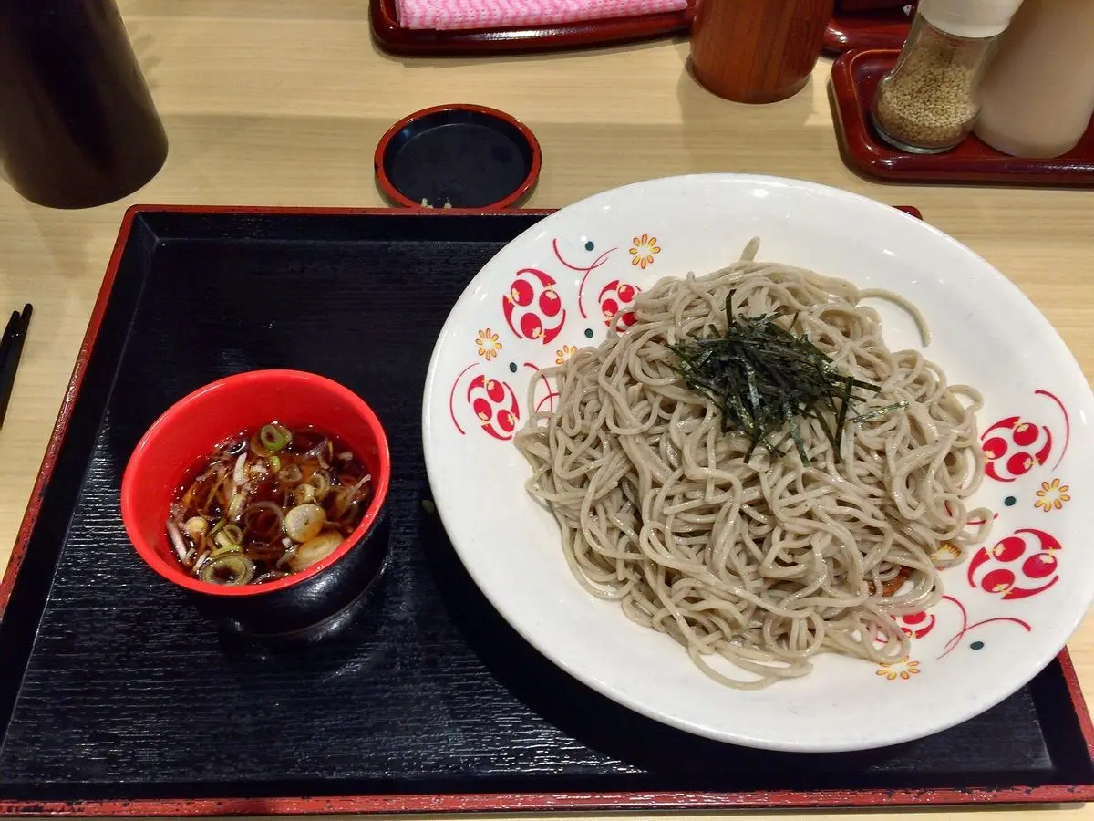 Plato de fideos soba fríos con alga nori y un cuenco de salsa para mojar