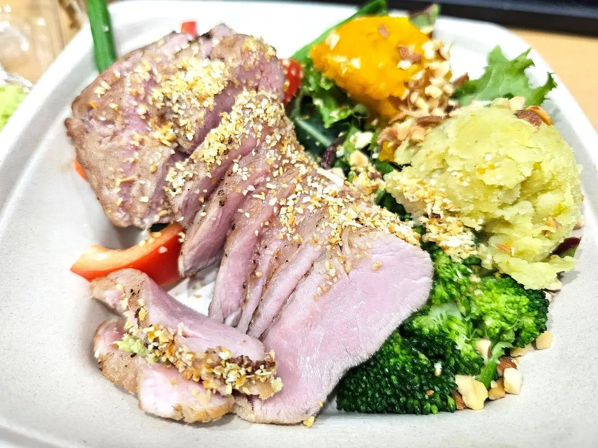 Plato con lonchas de solomillo de cerdo, puré de boniato y verduras verdes y brócoli