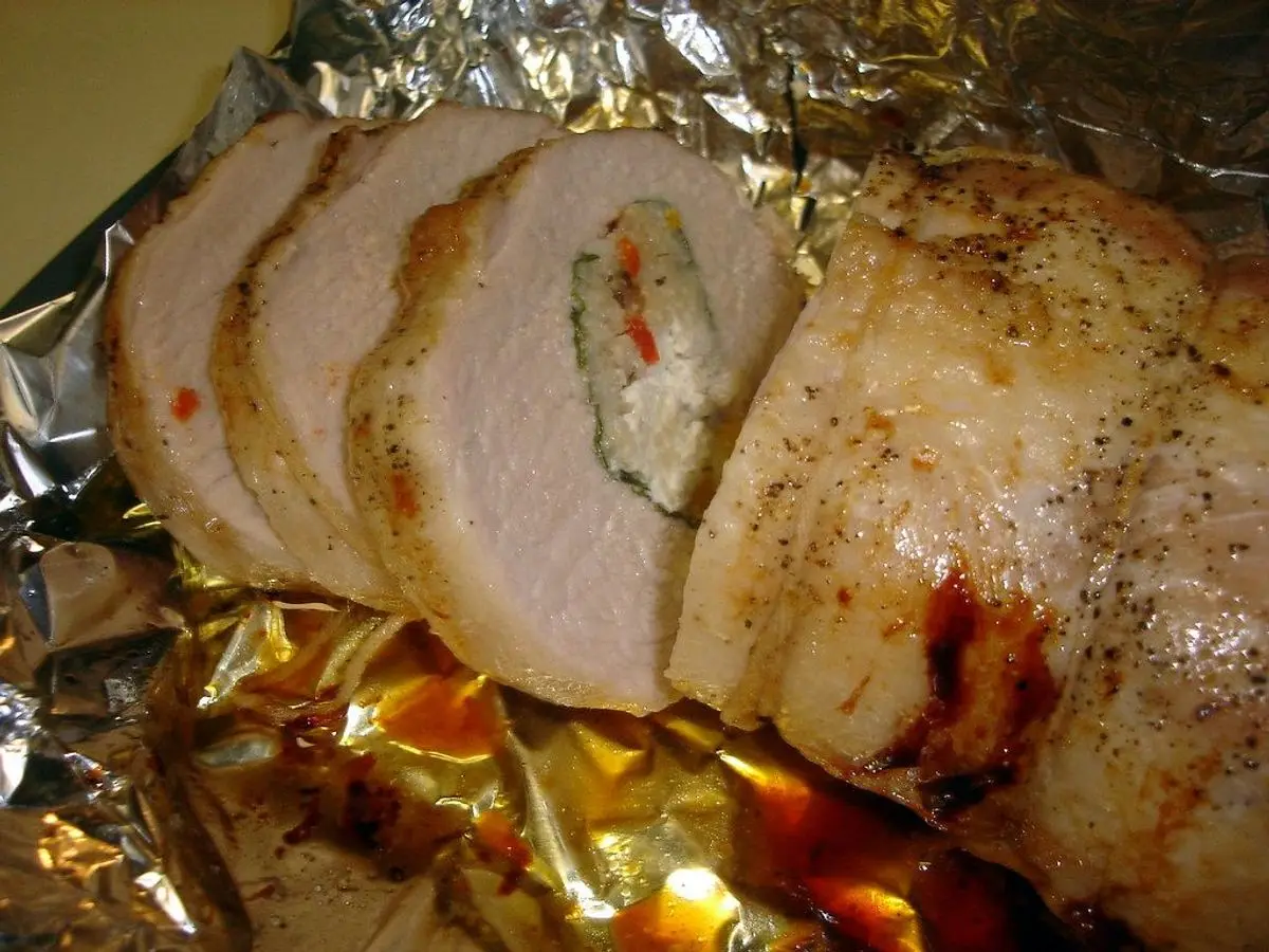 Solomillo de cerdo relleno cortado en rodajas sobre papel de aluminio