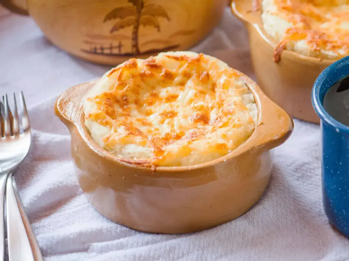 Cazuelita de barro con sonso de yuca y queso gratinado dorado al horno