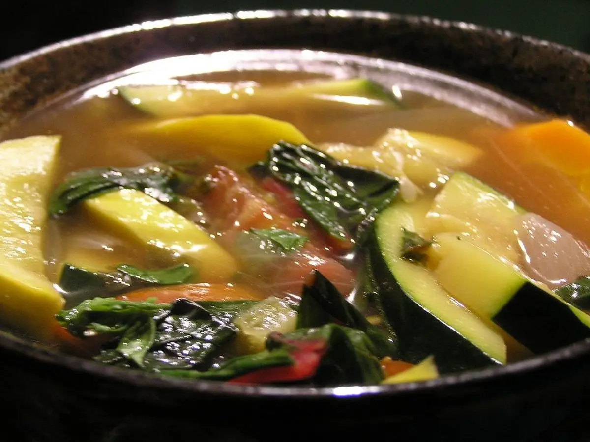Cuenco de sopa de verduras con calabacín, hojas de acelga y zanahoria en caldo