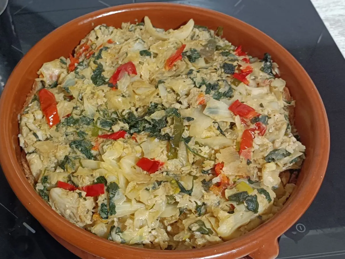 Cazuela de barro con sopas mallorquinas, col y tiras de pimiento rojo, cocinadas al horno