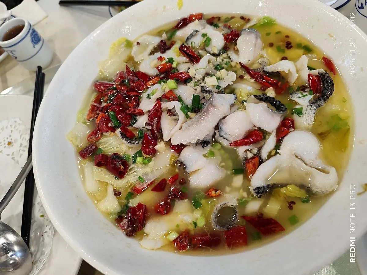 Plato hondo de láminas de pescado blanco en caldo con guindillas rojas y verduras