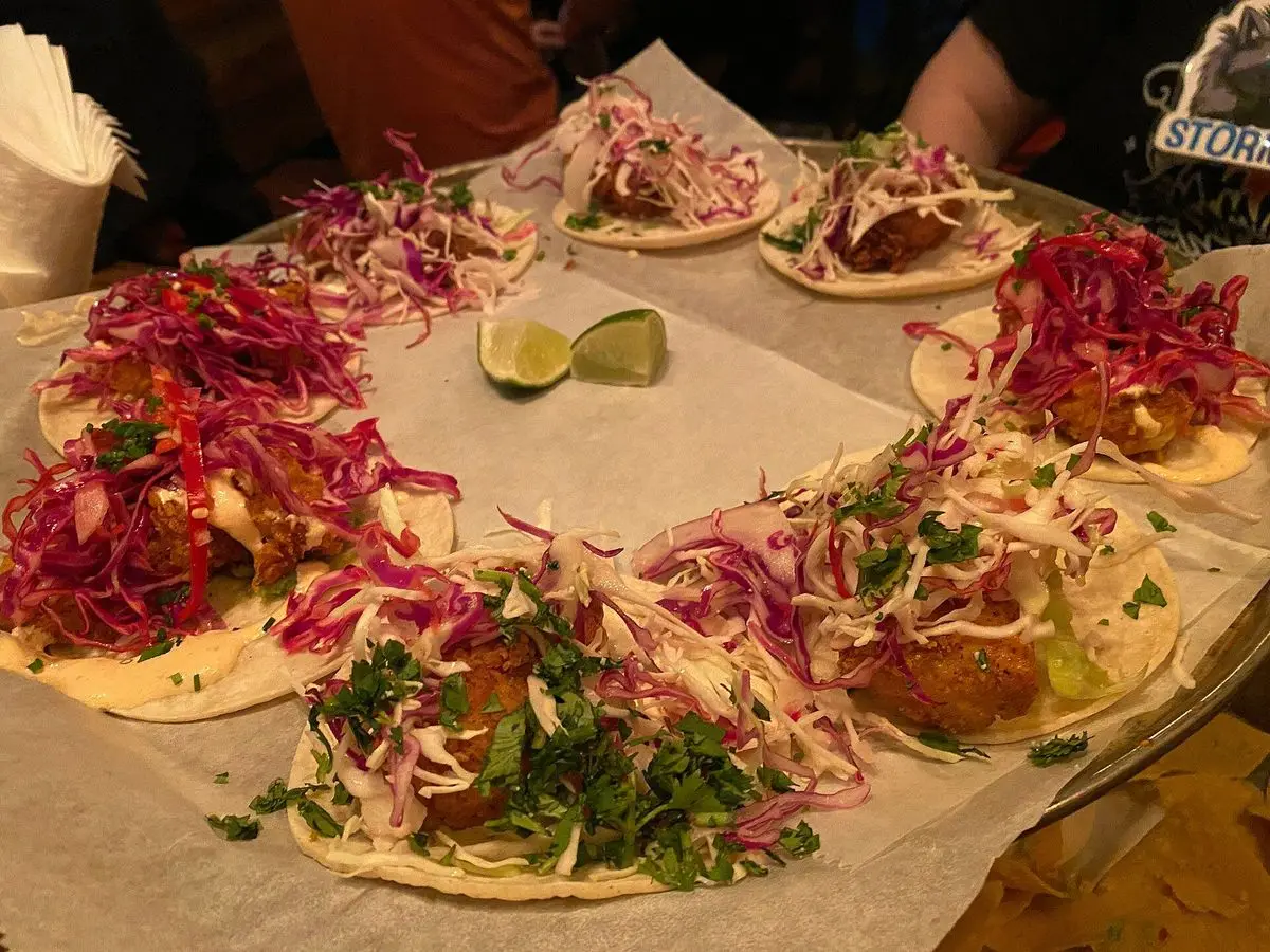 Tacos de pescado con repollo morado y lima servidos sobre papel