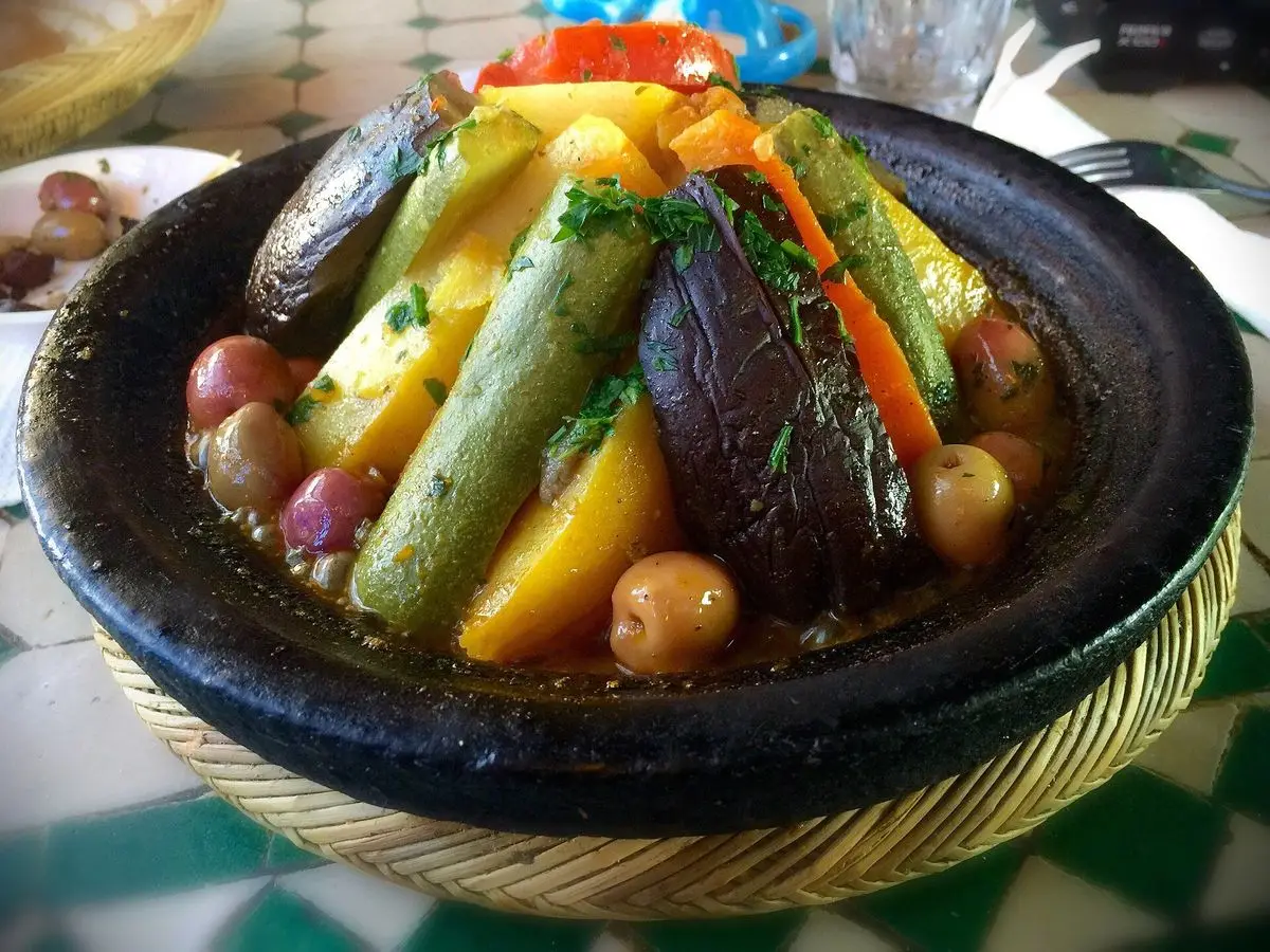 Tajín de verduras con calabacín, zanahoria, patata y berenjena colocadas en cazuela de barro oscura