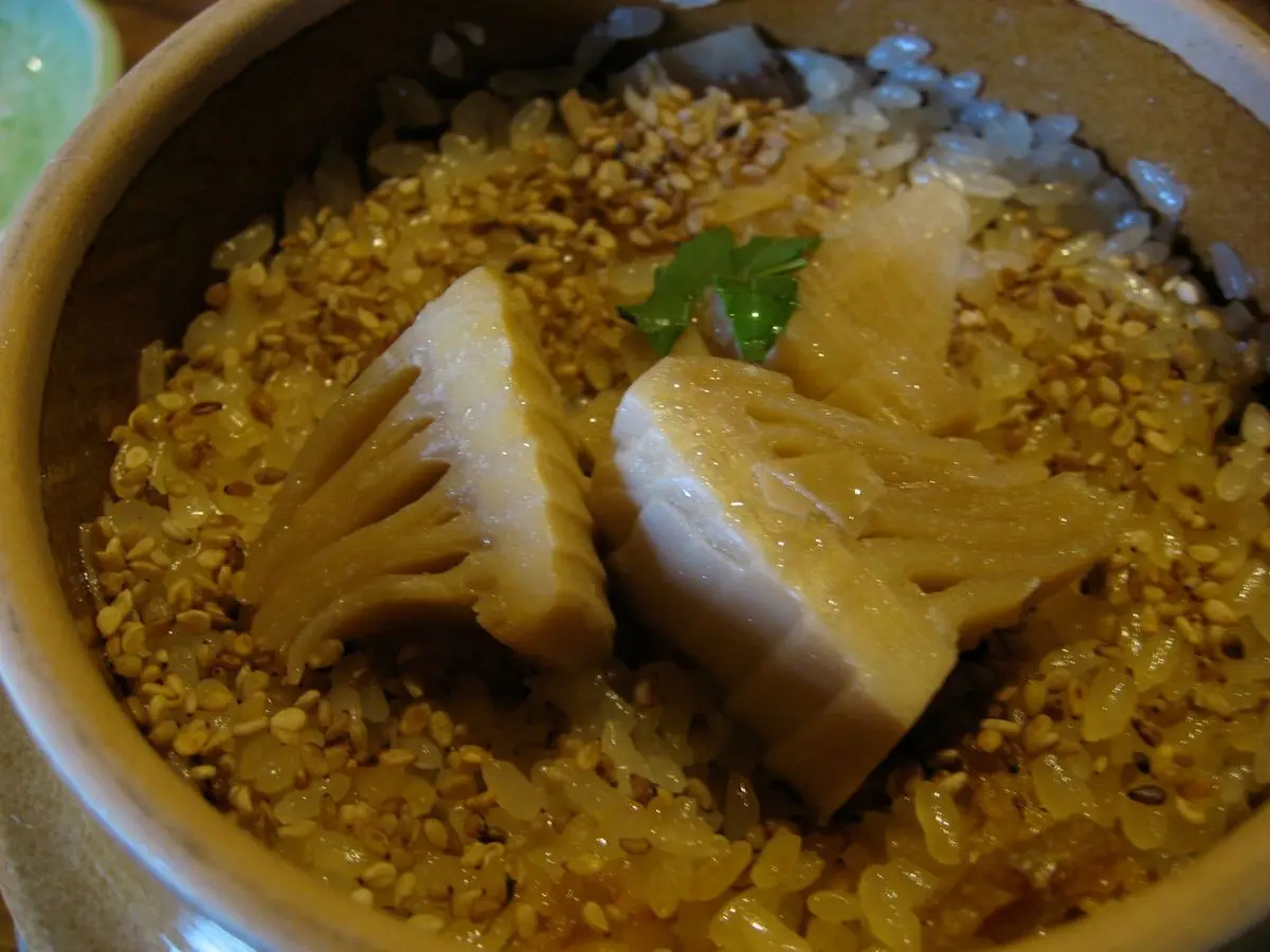 Olla de arroz japonés cocido con brotes de bambú y verduras, plato de arroz mixto
