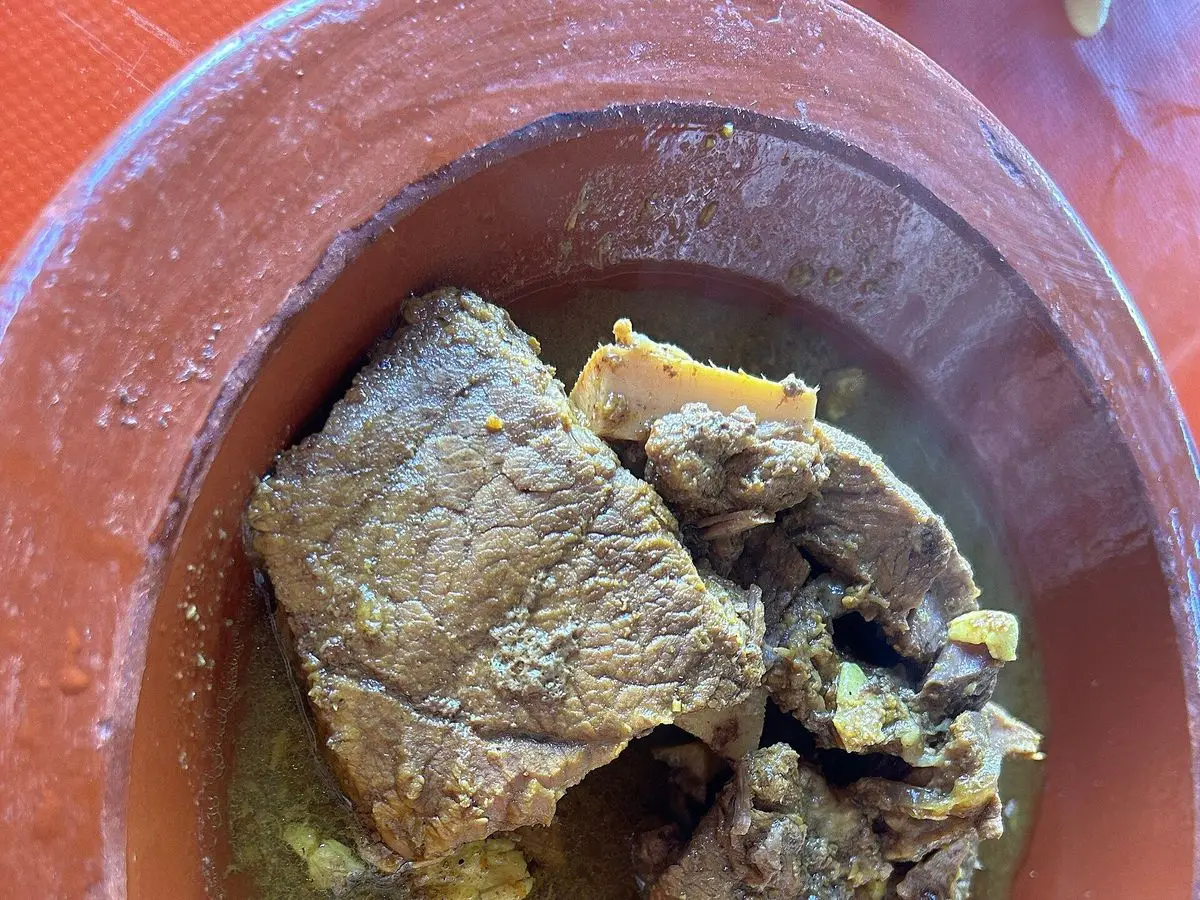Trozos de carne guisada con su jugo dentro de una vasija de barro