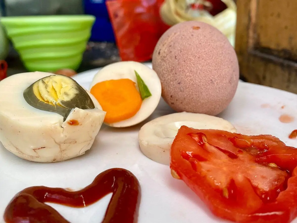 Plato con huevos duros partidos, zanahoria y tomate con un chorrito de kétchup