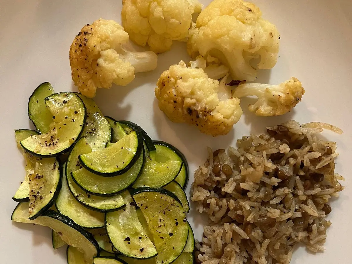 Plato vegano con calabacín a la plancha, coliflor asada y una guarnición de cereal integral