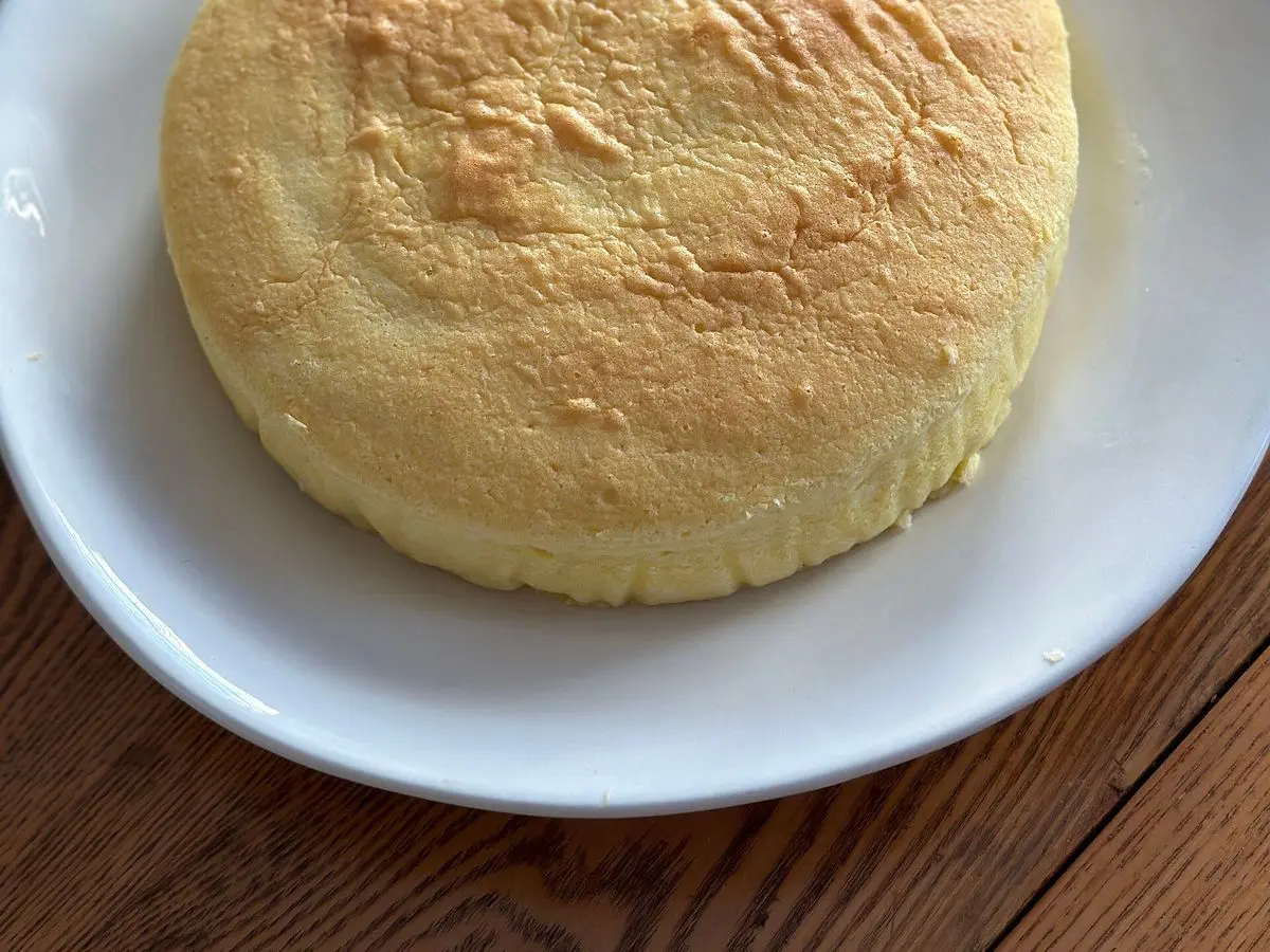Tarta de queso japonesa esponjosa y dorada sobre un plato blanco